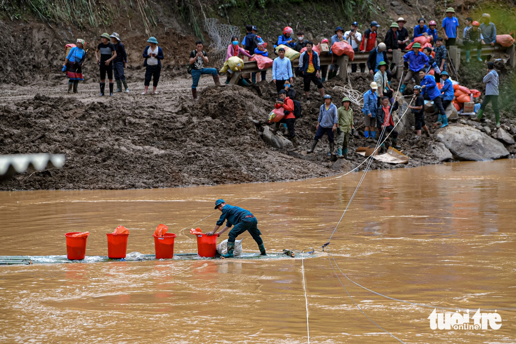 Using rafts to supply food, food, pots and pans to the people of De Sau village in Lao Chai commune - Photo: NAM TRAN