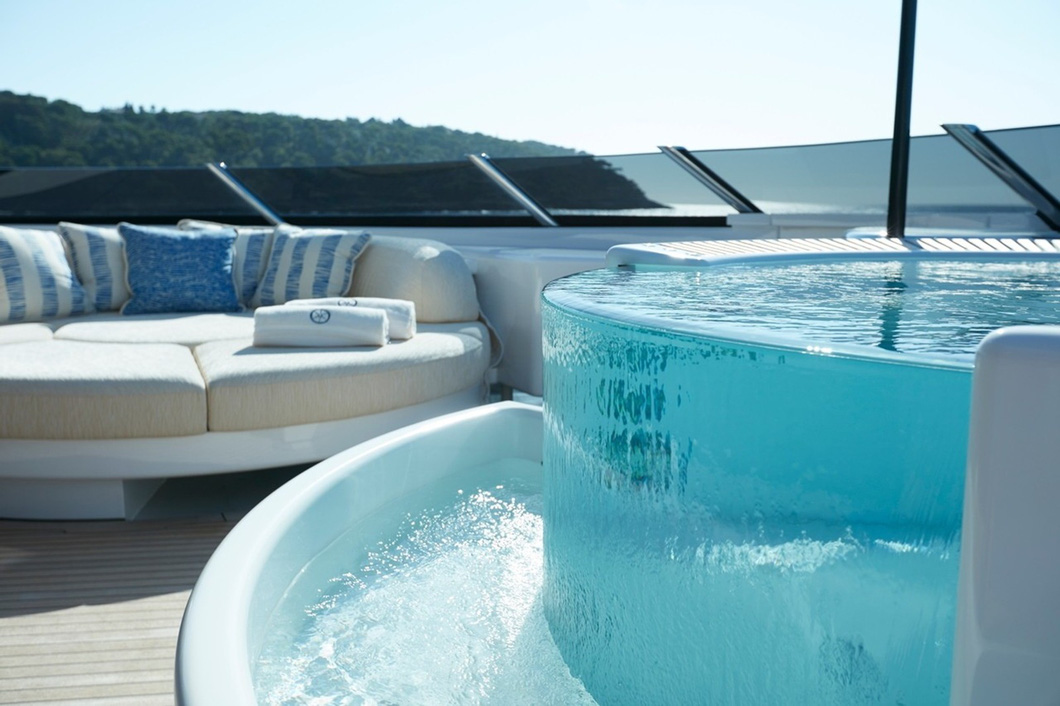 Huge superyacht influenced by luxury toys.  The back deck features an all-glass swimming pool and a stunning private waterfall.  Adjacent to this is a spacious seating area with an ultra-high resolution projection screen for epic movie nights.  There's also another cinema on the upper deck - Photo: Feadship