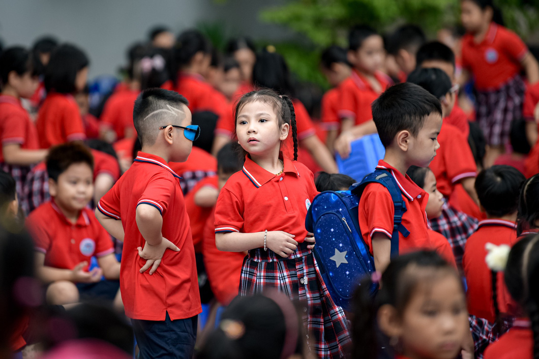 Lớp 1 vui nhưng cũng lạ lẫm. Một bé lớp 1 trường Tiểu học Nguyễn Du (Q. Nam Từ Liêm, Hà Nội) nhớn nhác tìm mẹ trong đám đông - Ảnh: NAM TRẦN