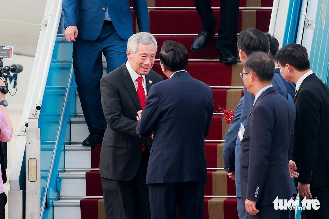 Bộ trưởng Bộ LĐ-TB&XH Đào Ngọc Dung đón Thủ tướng Singapore Lý Hiển Long tại chân cầu thang máy bay - Ảnh: NGUYỄN KHÁNH