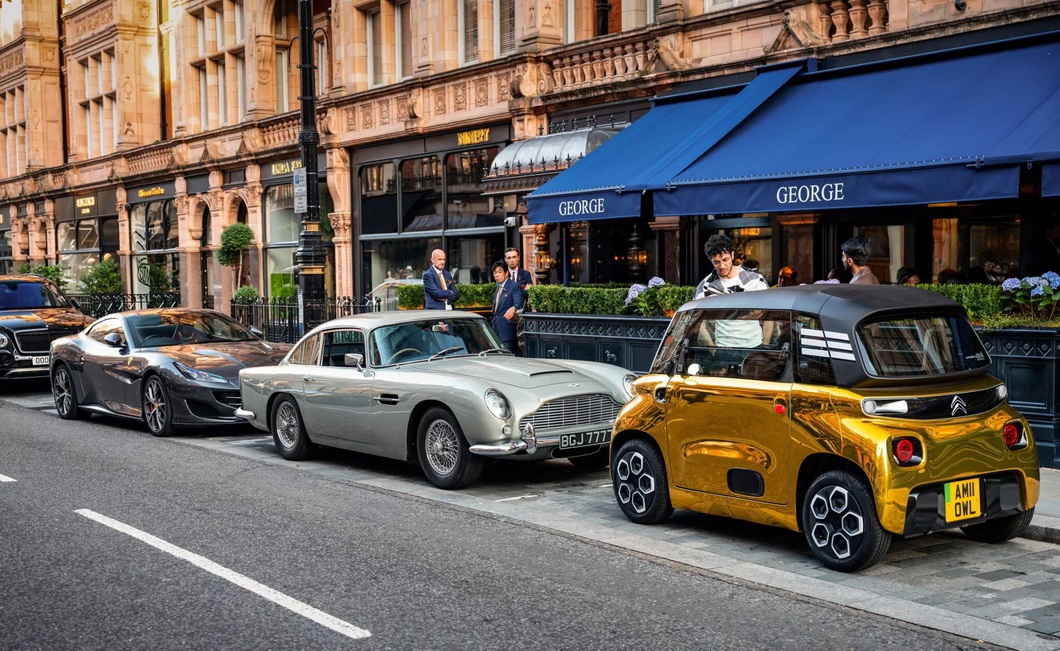 Electric mini car painted glistening like it's covered in gold, standing next to supercar Electric mini car painted glistening like it's covered in gold, standing next to supercar