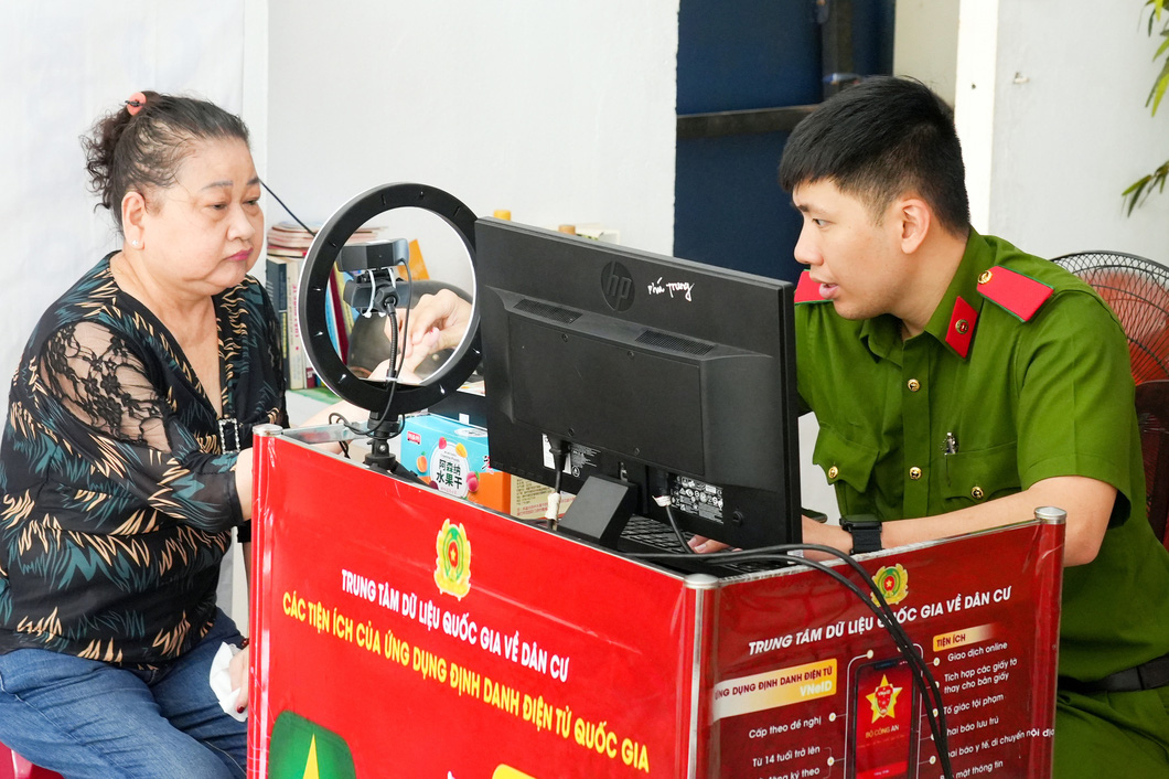 Công an viên làm thủ tục định danh mức 2 cho người dân ở quận Tân Phú, TP.HCM - Ảnh: HỮU HẠNH