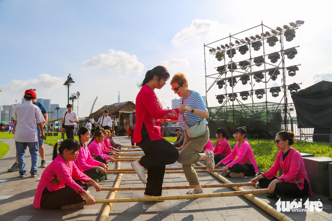 Du khách người Anh trải nghiệm trò chơi dân gian nhảy sạp ở công viên Bến Bạch Đằng - Ảnh: PHƯƠNG QUYÊN