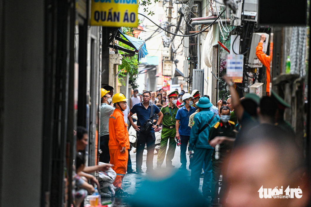 Lực lượng chức năng phong tỏa con ngõ nơi có căn nhà gặp nạn - Ảnh: HỒNG QUANG