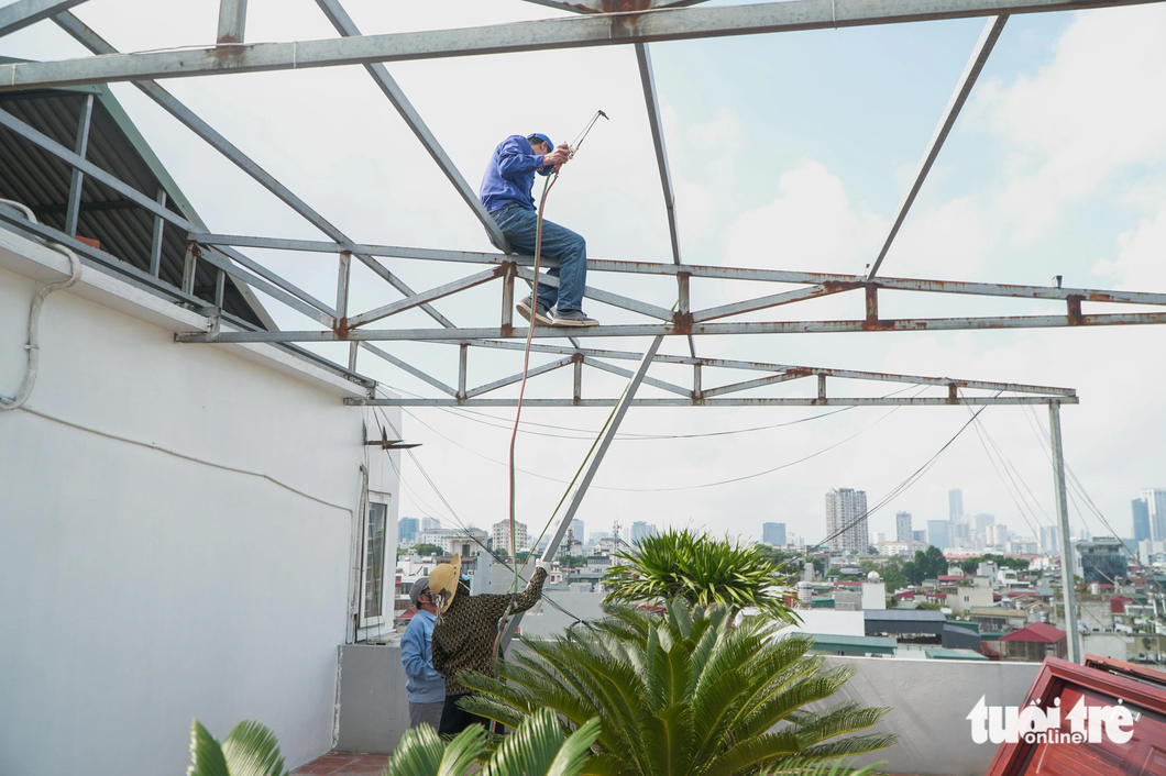 Các khung sắt trên tầng thượng được tháo dỡ - Ảnh: PHẠM TUẤN