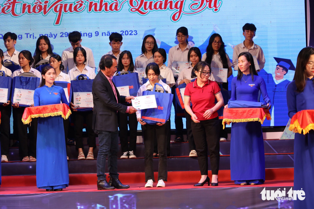 Ông Lê Quốc Phong, nguyên chủ nhiệm CLB Nghĩa tình Quảng Trị, trao học bổng cho các tân sinh viên - Ảnh: HOÀNG TÁO