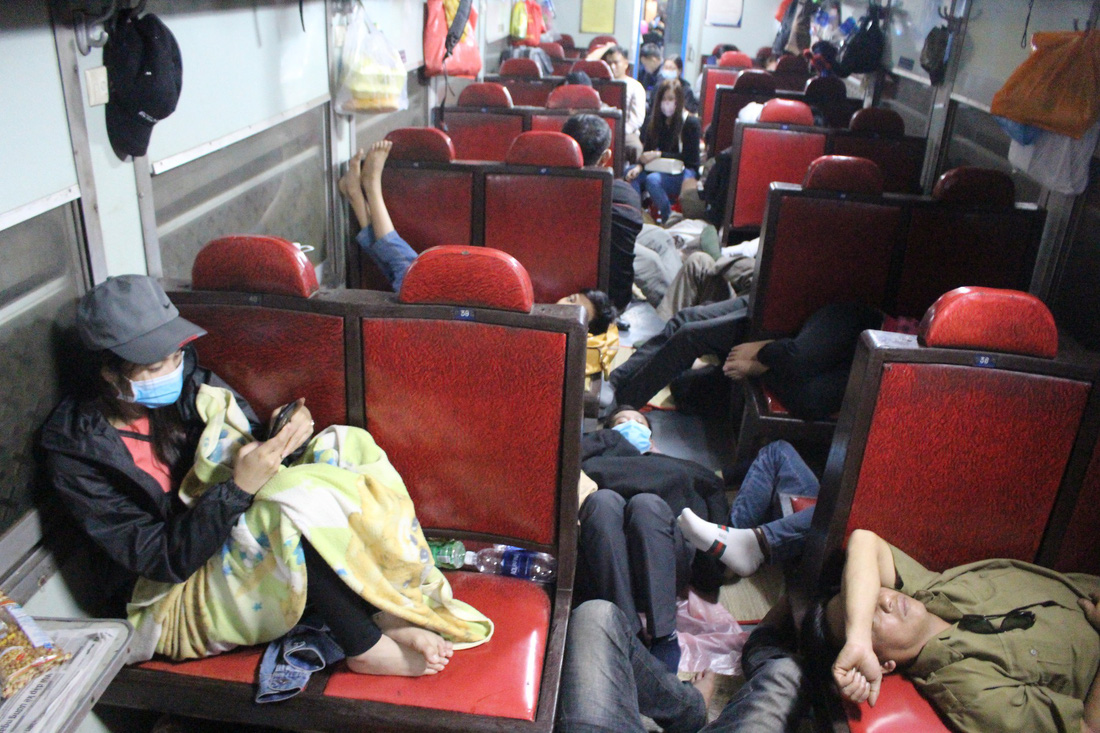 Hành khách phải ngủ gầm ghế, ngồi ngay cửa nhà vệ sinh trên tàu - Ảnh 2.