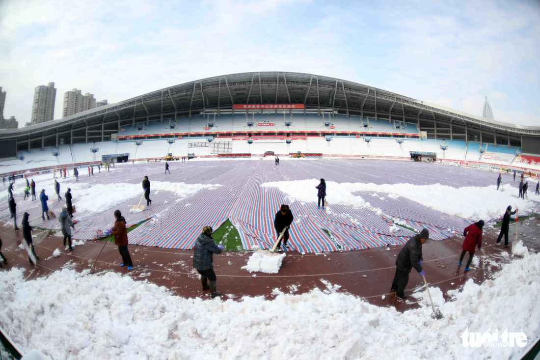 Dọn sạch tuyết trên sân vận động nơi U23 Việt Nam đá chung kết - Ảnh 1.