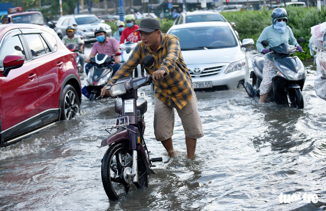 Triều cường chưa đạt đỉnh, người dân đã bì bõm lội nước giờ tan tầm - Ảnh 8.