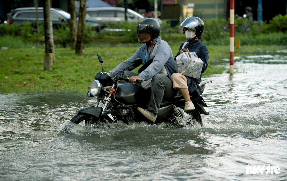 Triều cường chưa đạt đỉnh, người dân đã bì bõm lội nước giờ tan tầm - Ảnh 10.