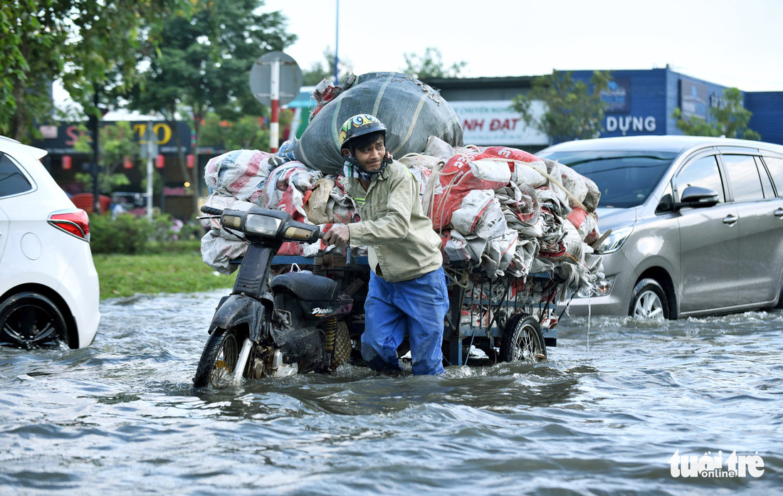 Triều cường chưa đạt đỉnh, người dân đã bì bõm lội nước giờ tan tầm - Ảnh 2.