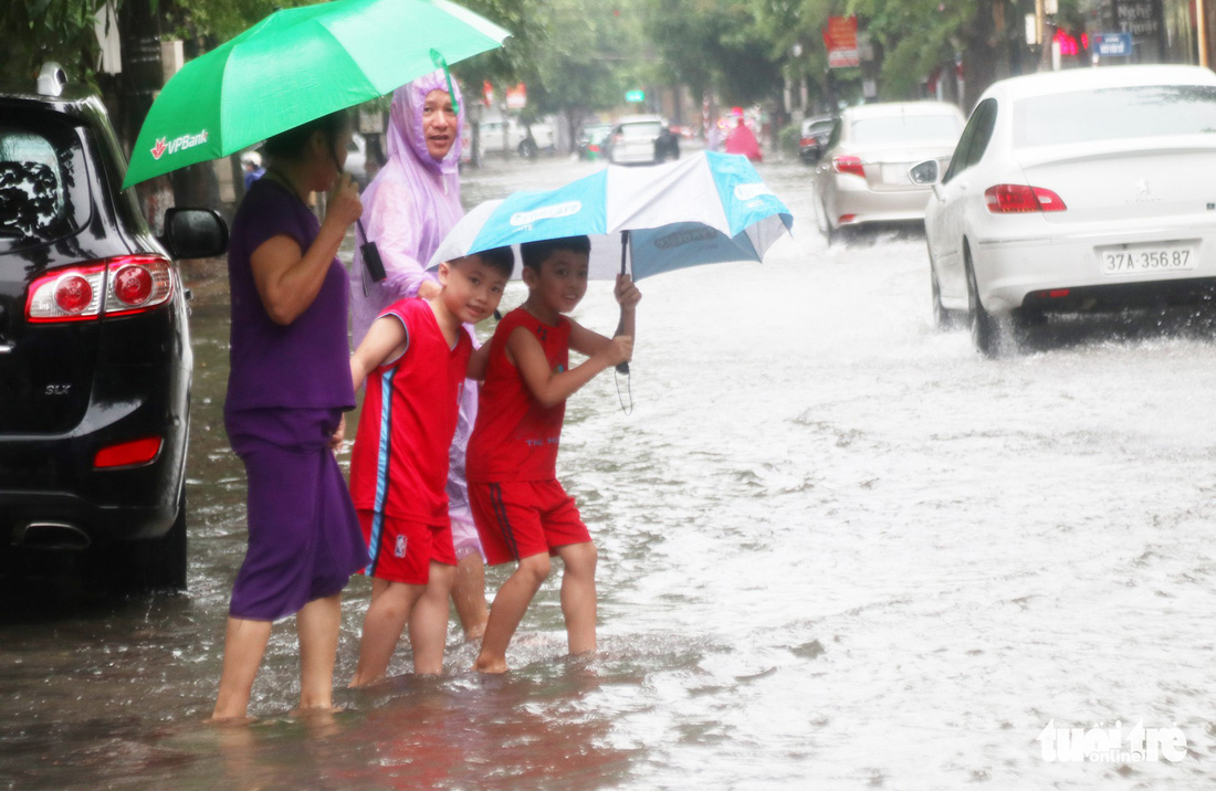 TP Vinh mưa xối xả ngập đường, phụ huynh vất vả đưa con đến trường - Ảnh 6.
