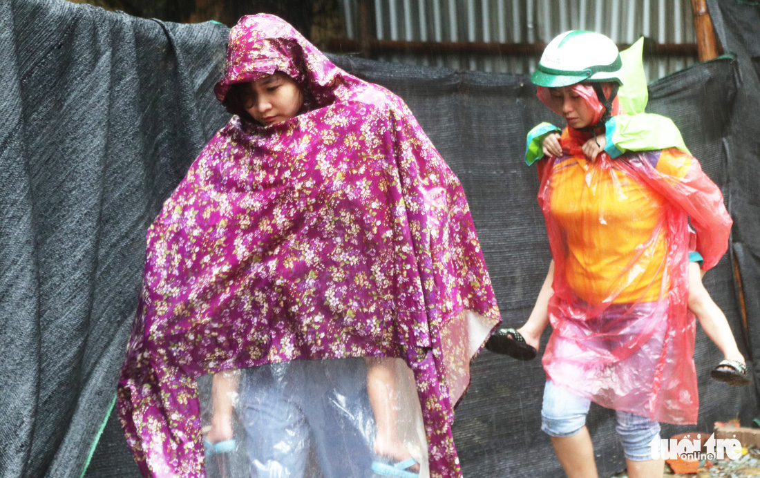 TP Vinh mưa xối xả ngập đường, phụ huynh vất vả đưa con đến trường - Ảnh 1.