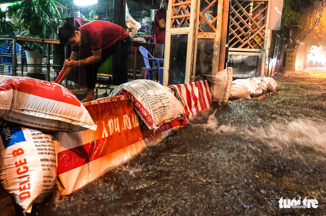Mưa lớn đường Sài Gòn mênh mông dậy sóng, dân đắp đê ngăn nước - Ảnh 3.