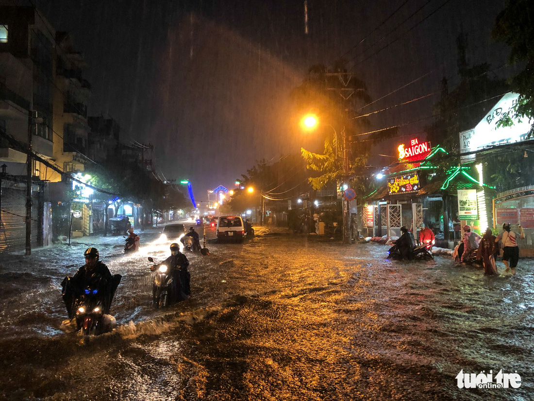 Mưa lớn đường Sài Gòn mênh mông dậy sóng, dân đắp đê ngăn nước - Ảnh 4.
