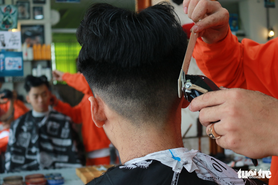 Tiệm cắt tóc giá 2.000 đồng của những anh thợ áo cam - Ảnh 3.