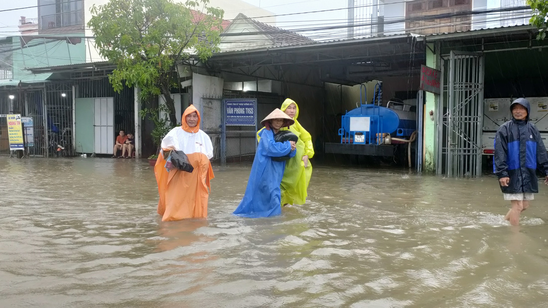 Mưa lớn, nước tràn ngập quốc lộ 1, dân Quảng Nam hối hả sơ tán - Ảnh 8.