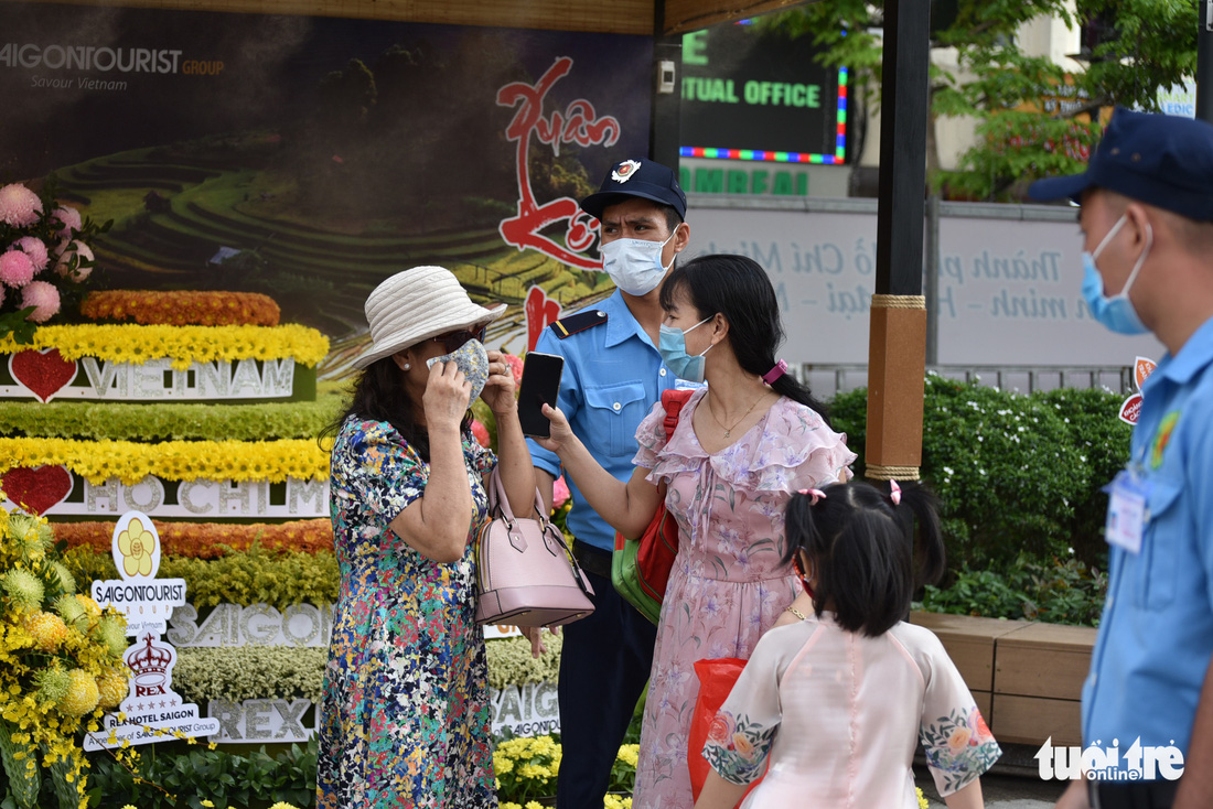 Người dân vẫn lơ là gỡ khẩu trang khi đi đường hoa Nguyễn Huệ - Ảnh 1.