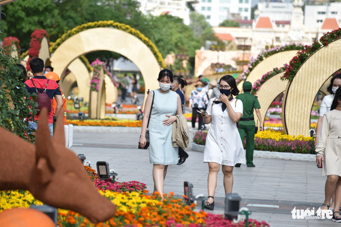 Người dân vẫn lơ là gỡ khẩu trang khi đi đường hoa Nguyễn Huệ - Ảnh 14.