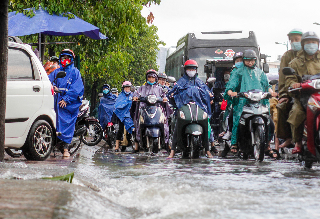 Đường Phạm Văn Đồng ngập, kẹt xe sau mưa lớn, CSGT phải moi rác cho nước chảy - Ảnh 5.