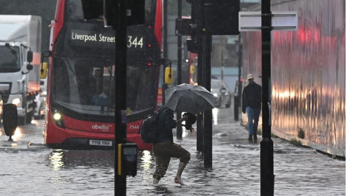 Mưa lũ bất thường biến nhiều con đường ở London thành sông - Ảnh 1.