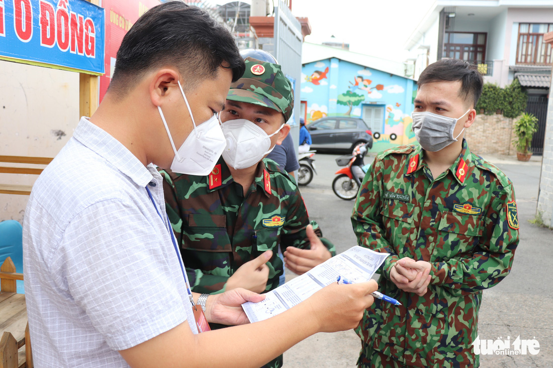 Khoác đồ bảo hộ, học viên Học viện Quân y tận tình hướng dẫn người dân TP.HCM test nhanh tại nhà - Ảnh 2.