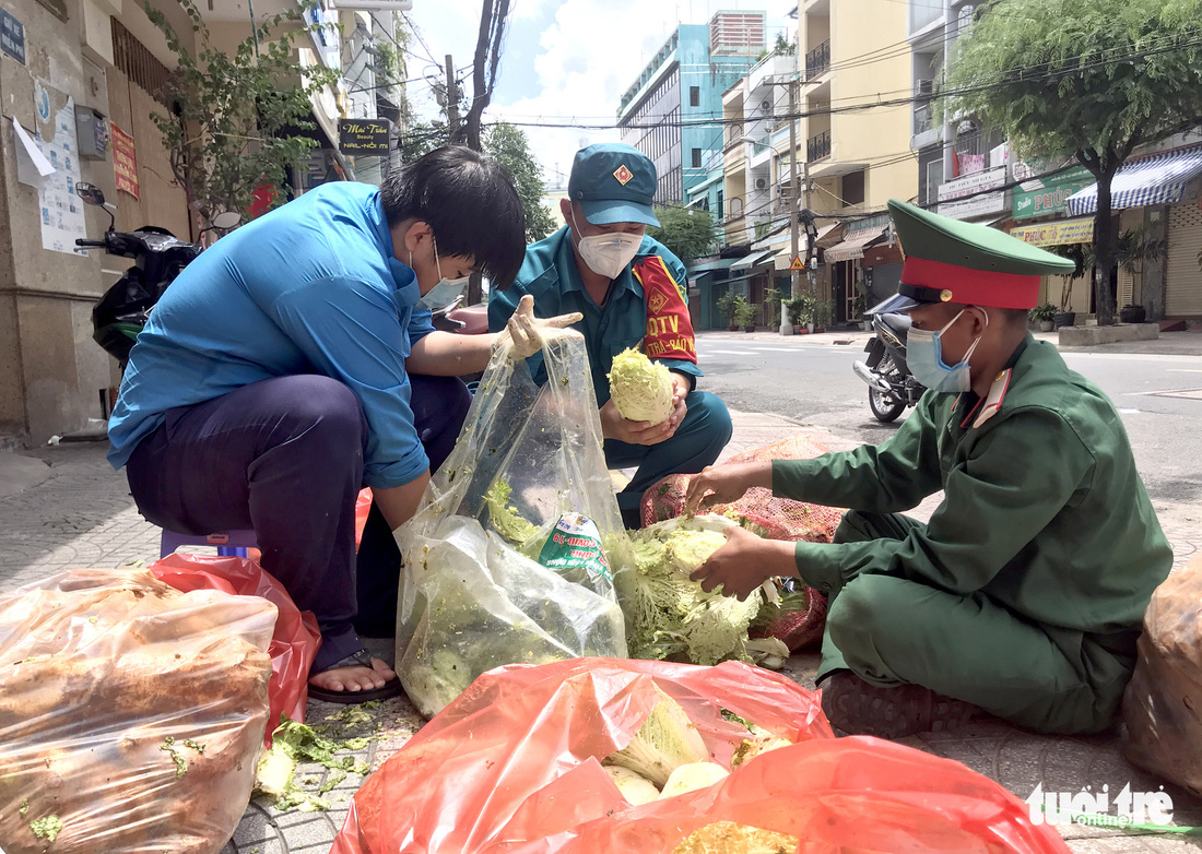 Cán bộ phường cùng bộ đội xắn tay lặt rau, đóng gói thực phẩm mang cho dân - Ảnh 1.