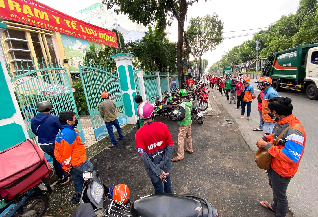 Hàng chục shipper đứng chờ trước điểm xét nghiệm COVID-19 lưu động trên đường Quang Trung, quận Gò Vấp - Ảnh: QUANG ĐỊNH