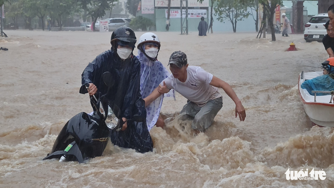 Mưa lớn kéo dài tại Quy Nhơn, xe máy và người đi đường bị nước cuốn - Ảnh 4.