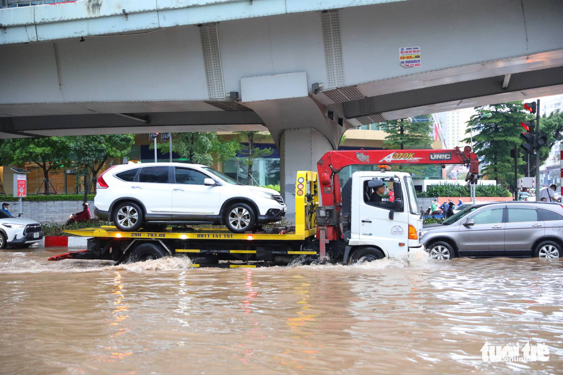 Đường phố Hà Nội hỗn loạn, ùn tắc dài sau cơn mưa 160mm hiếm gặp - Ảnh 3.