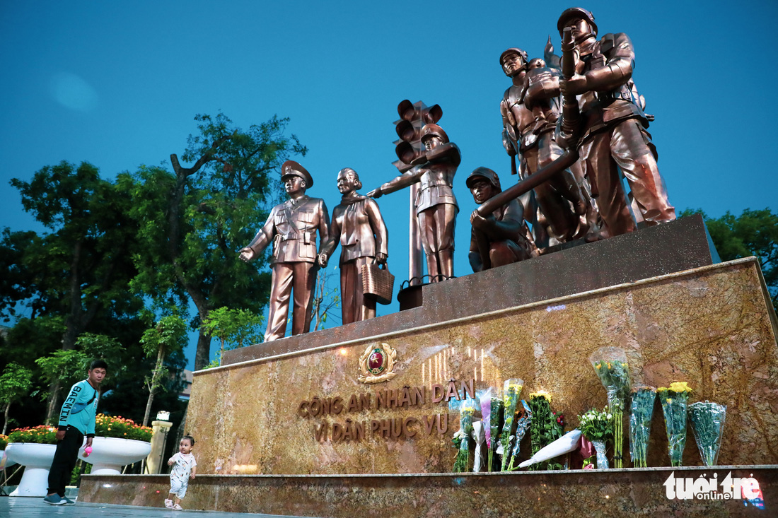 Người dân đến tượng đài Công an nhân dân đặt hoa tưởng niệm 3 cảnh sát chữa cháy hy sinh - Ảnh 1.