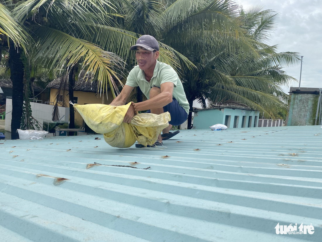 Dân ven biển Quảng Nam xúc cát, cột dây thừng chằng chống nhà cửa, hàng quán tránh bão - Ảnh 4.