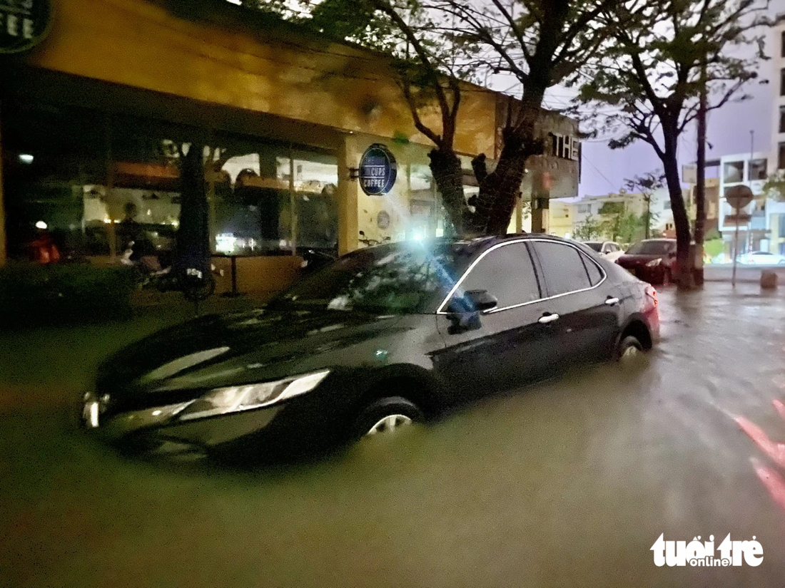 Một chiếc xe đậu trên vỉa hè đường Lê Thanh Nghị nhưng vẫn không thoát khỏi tình cảnh bị ngập vào đêm 14-10-2022 - Ảnh: TRƯỜNG TRUNG