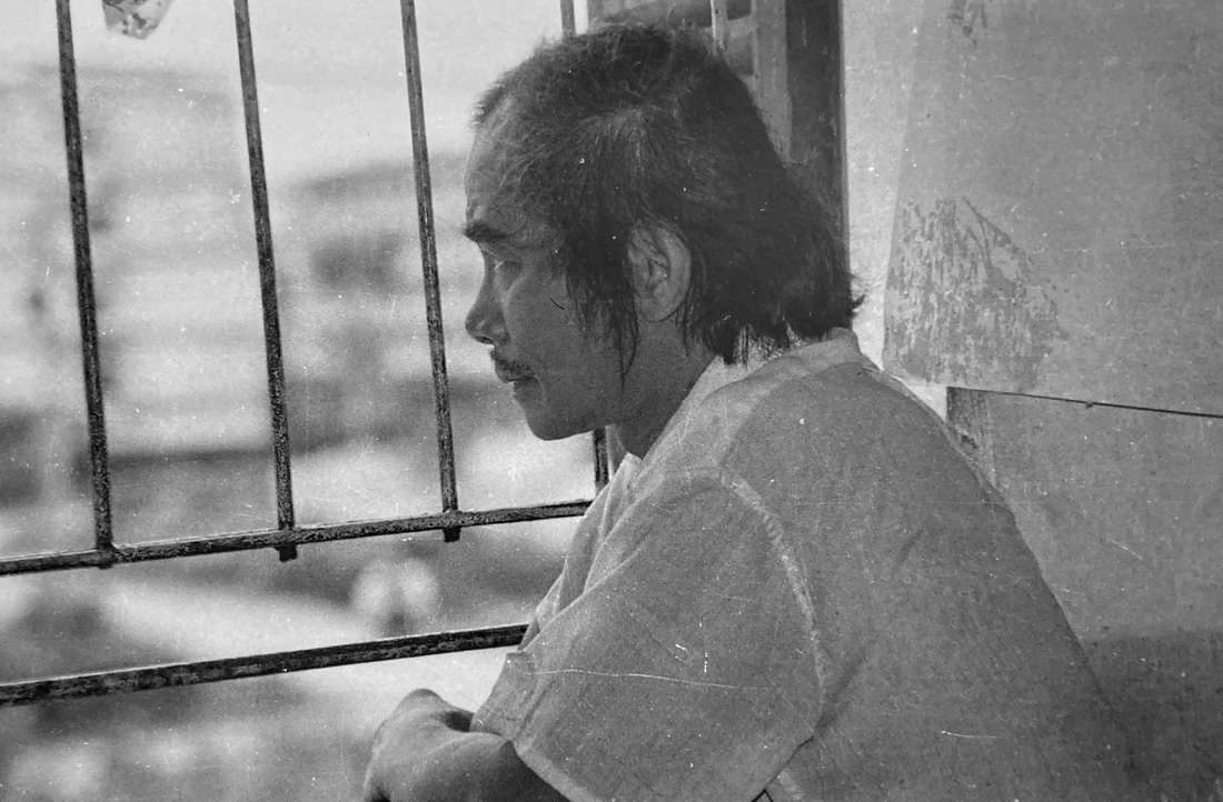 Đặng Đình Hưng trong căn nhà tập thể, ông thường ngồi nhìn xuống phố qua những chấn song ban công, một hình ảnh giàu sức gợi về cuộc đời của thi sĩ