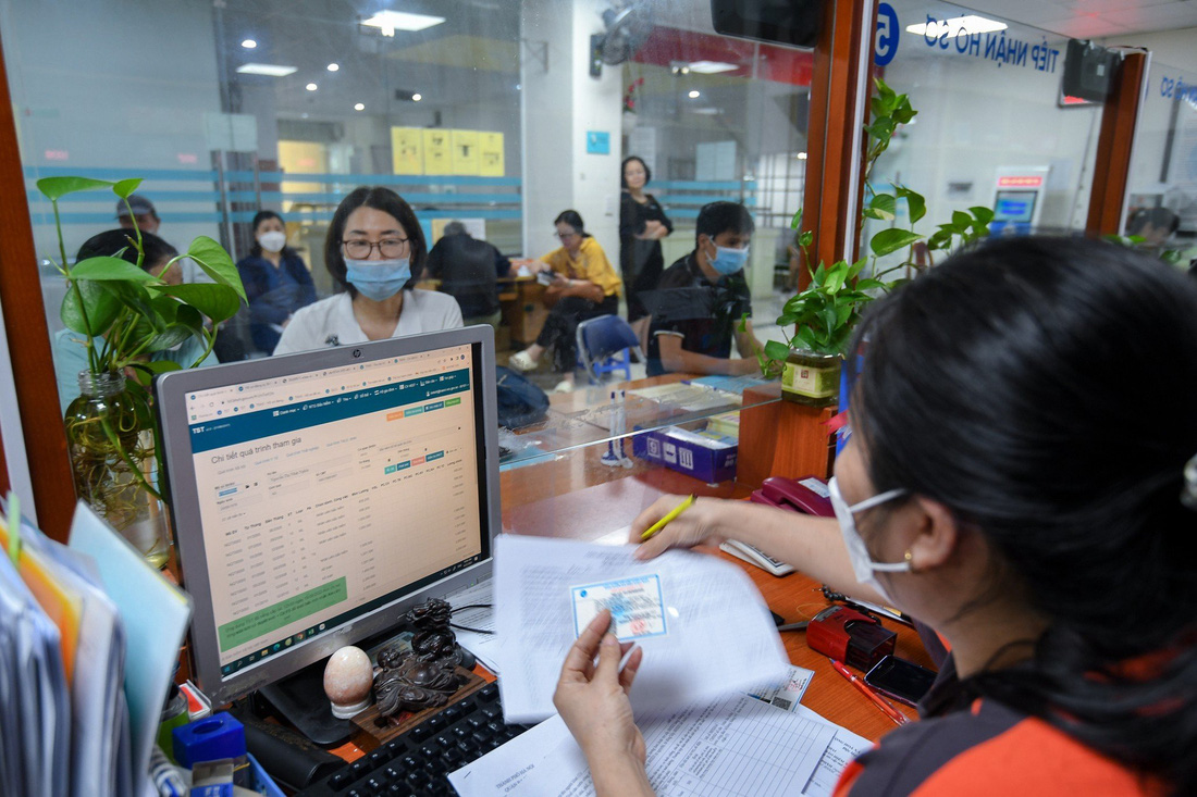 Người dân làm thủ tục liên quan đến bảo hiểm y tế tại Bảo hiểm xã hội quận Ba Đình, Hà Nội - Ảnh: NAM TRẦN