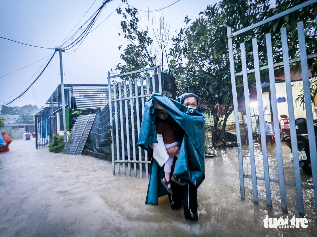 Người dân tổ 65 phường Hòa Khánh Nam bồng bế con nhỏ di tản khỏi nhà vì nước lên nhanh - Ảnh: TẤN LỰC