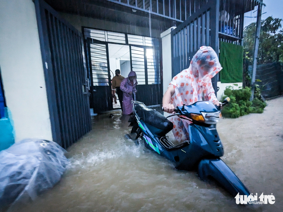 Những chiếc xe máy đã ngập nước cũng được dắt đi tránh lũ - Ảnh: TẤN LỰC