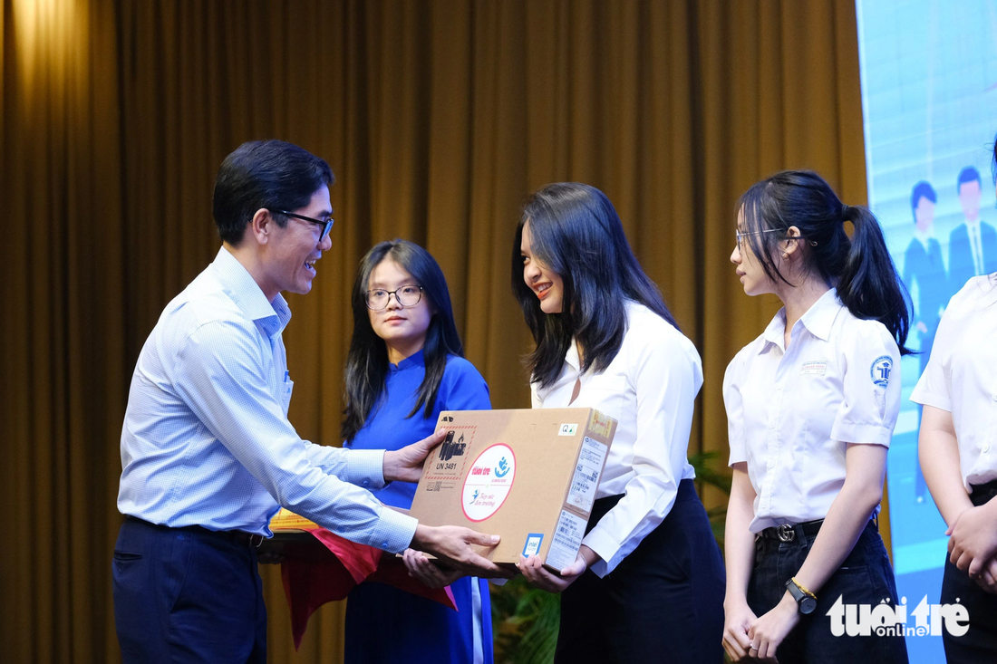 Ông Hồ Tấn Vũ, trưởng Văn phòng đại diện báo Tuổi Trẻ tại Trung Bộ, trao laptop cho 3 tân sinh viên có hoàn cảnh đặc biệt - Ảnh: TẤN LỰC