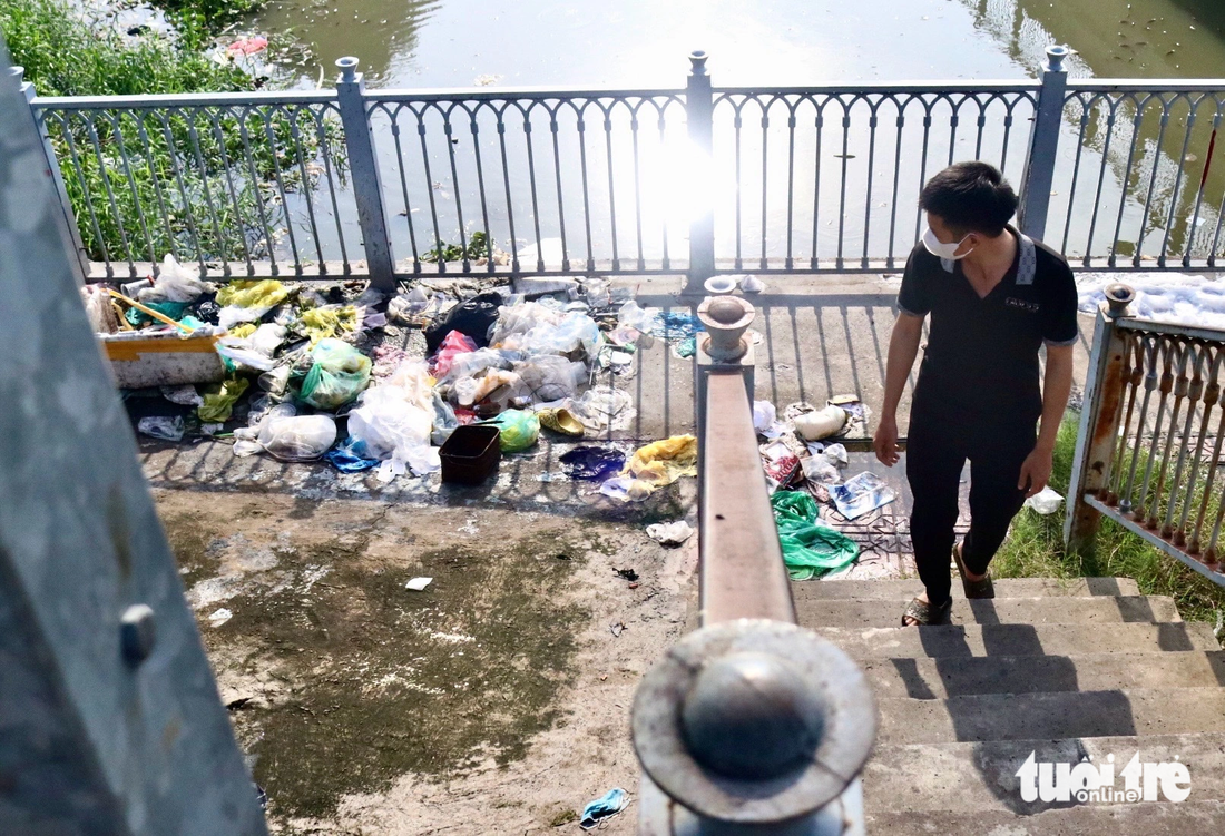 Người dân ngao ngán trước bãi rác tự phát bên cạnh con kênh - Ảnh: TIẾN QUỐC