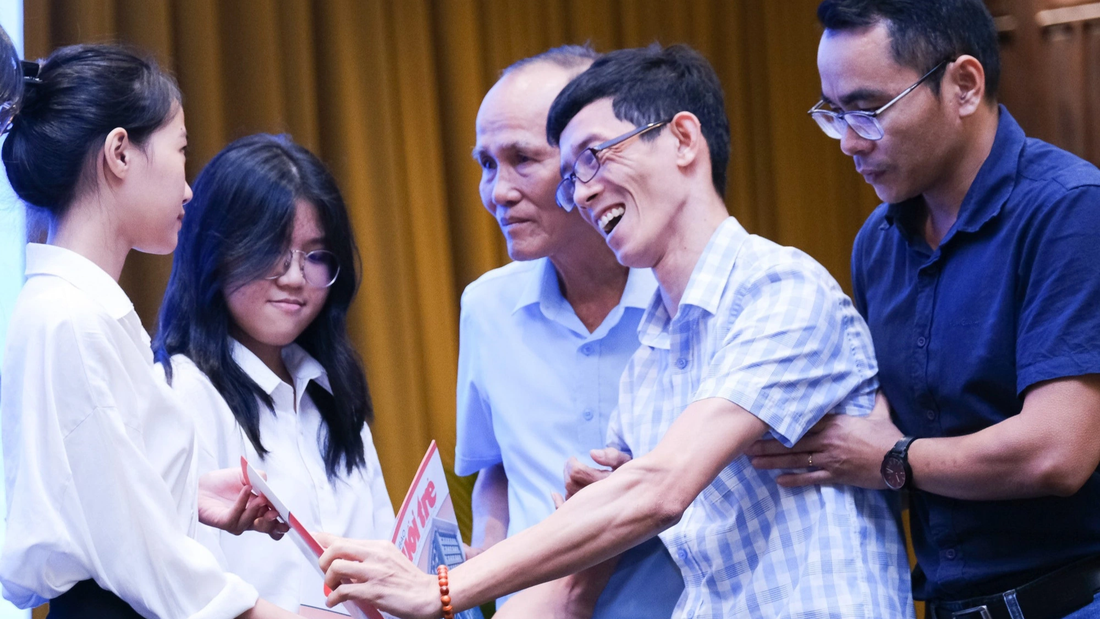 Anh kỹ sư bại não Nguyễn Hoàng Gia Bảo (thứ hai, từ phải sang), từng nhận học bổng Tiếp sức đến trường 14 năm trước, trao quà cho tân sinh viên nhận học bổng năm nay - Ảnh: TẤN LỰC