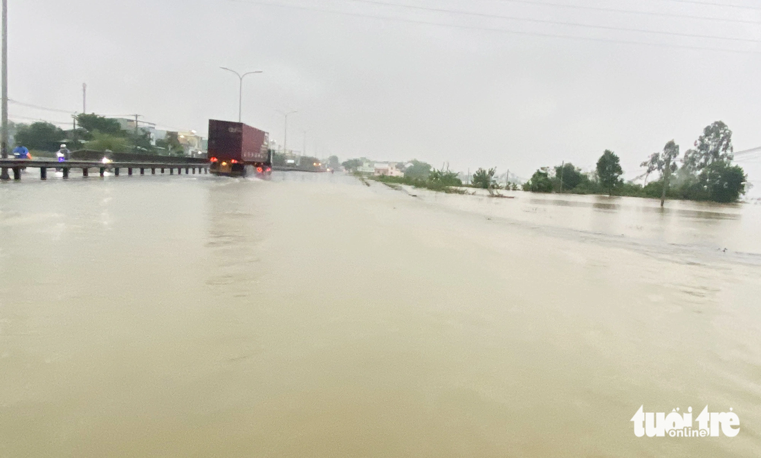 Nước lũ tràn lênh láng trên quốc lộ 1 đoạn qua xã Tam Đàn, huyện Phú Ninh, Quảng Nam - Ảnh: LÊ TRUNG