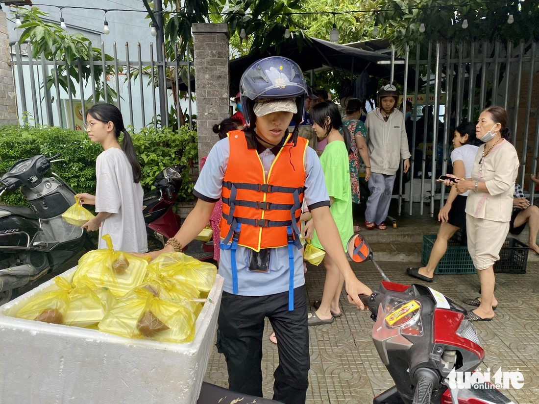 Cơm nóng liên tục tiếp sức cho bà con dọn lụt trong vùng ngập quận Liên Chiểu, Đà Nẵng - Ảnh: TRƯỜNG TRUNG