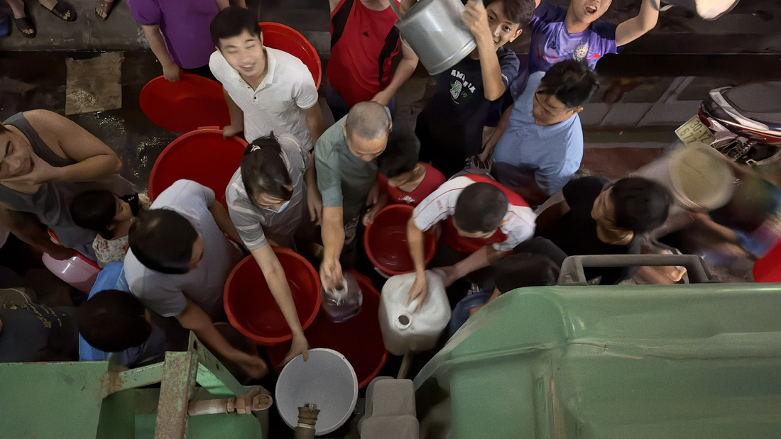 Người dân xếp hàng xách nước ở sảnh chung cư Thanh Hà - Ảnh: Người dân cung cấp