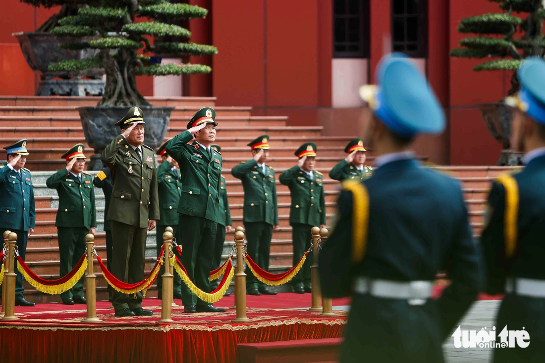 Thượng tướng Nguyễn Tân Cương và Đại tướng Vong Pisen đứng trên bục danh dự nghe quân nhạc cử quốc thiều hai nước