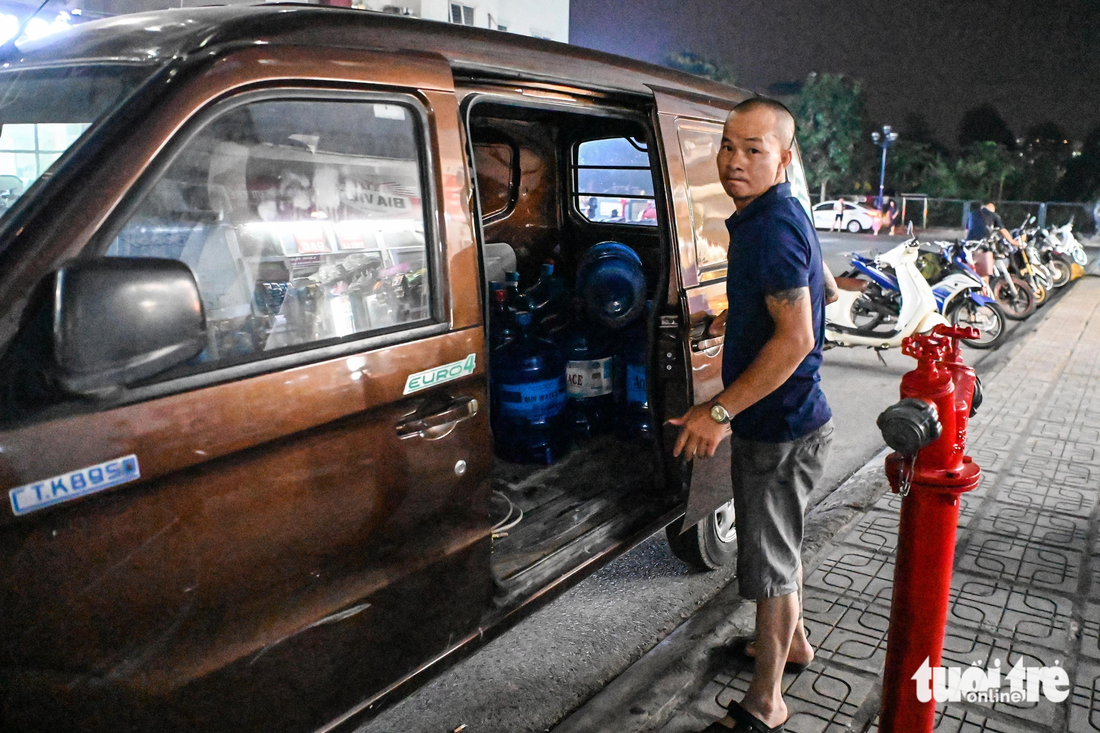 Không thể chờ đợi, người đàn ông này quyết định mua 30 thùng nước về cho gia đình sử dụng - Ảnh: HỒNG QUANG