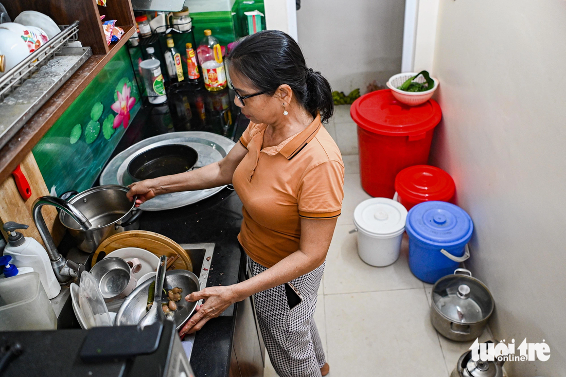 Trong khi đó, bà Đặng Thị Phương Hoa đang loay hoay với chồng bát đũa đã 3 ngày chưa rửa. Nhiều chiếc trong số đó đã lên những vệt mốc xanh, mốc đỏ - Ảnh: HỒNG QUANG