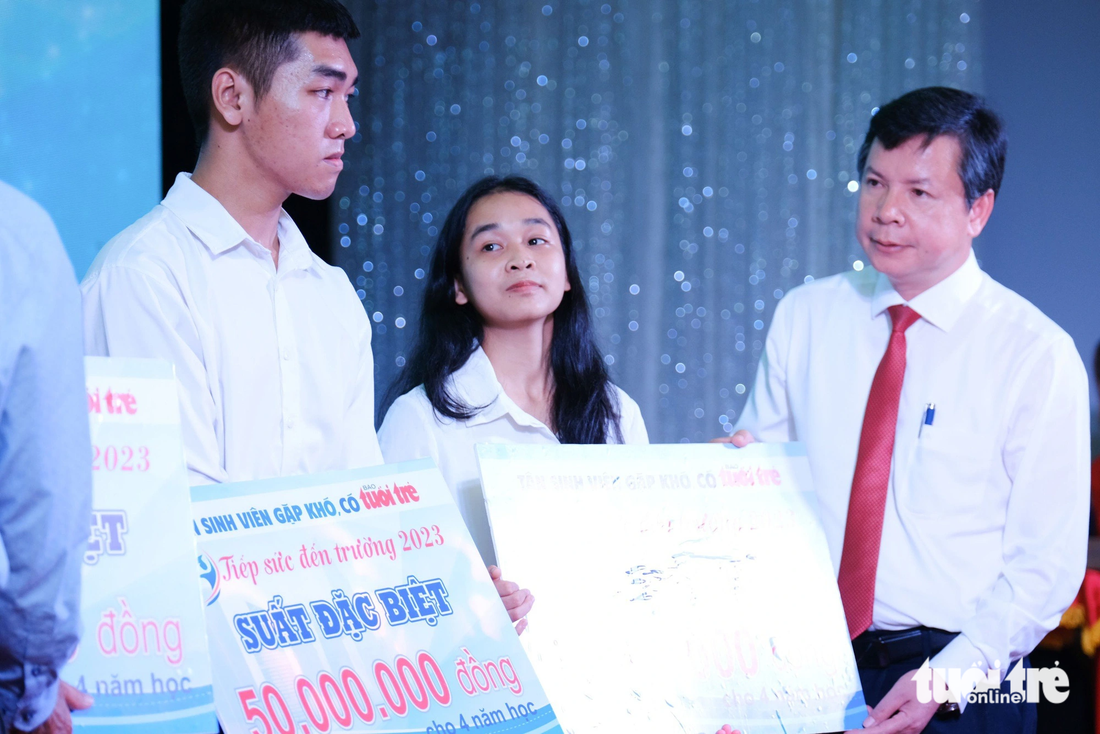 Ông Nguyễn Tân, giám đốc Sở GD-ĐT tỉnh Thừa Thiên - Huế trao suất học bổng đặc biệt 50 triệu đồng cho các tân sinh viên - Ảnh: TẤN LỰC