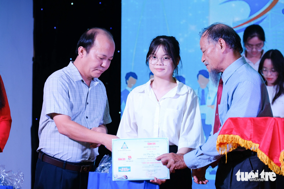 PGS.TS Nguyễn Thiện Tống (phải) và ông Mai Lương Xuân Hoài, đại diện Ban Tuyên giáo Tỉnh ủy Thừa Thiên - Huế, trao học bổng - Ảnh: TẤN LỰC
