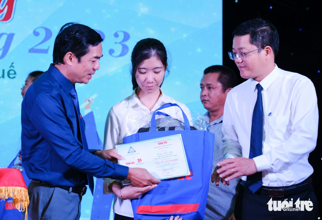 Nhà báo Nguyễn Khắc Cường (trái) và anh Nguyễn Thanh Hoài, bí thư Tỉnh đoàn Thừa Thiên - Huế, trao học bổng cho sinh viên - Ảnh: TẤN LỰC