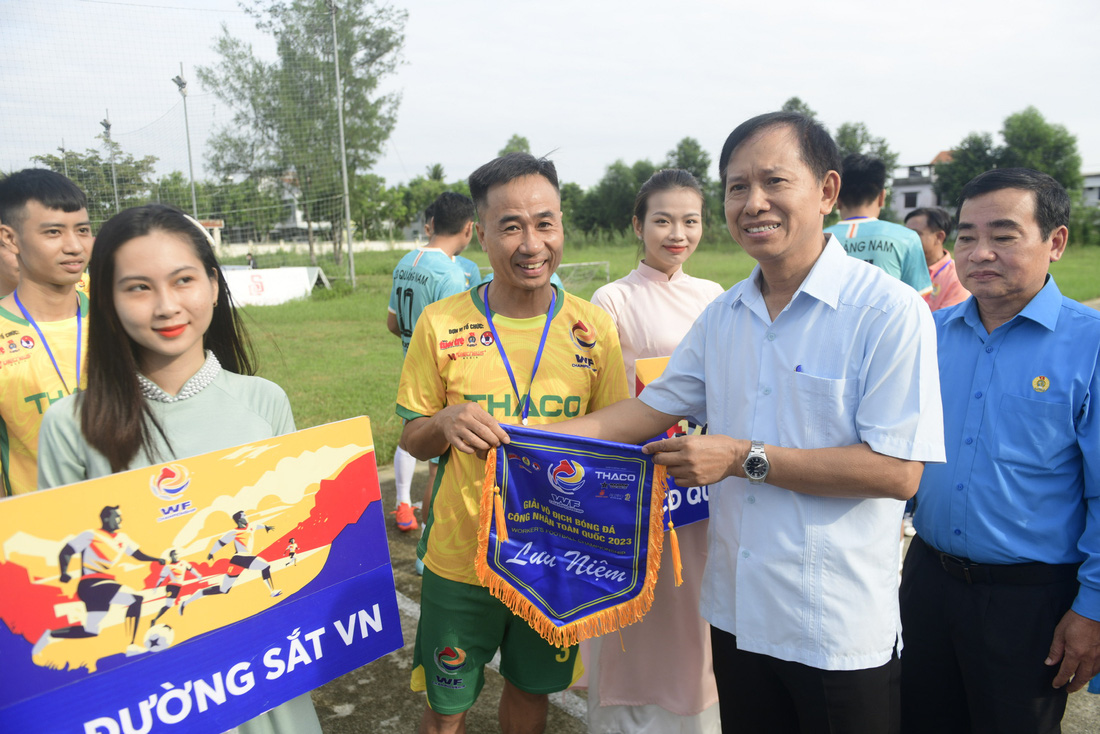 Ông Vũ Mạnh Tiêm - phó trưởng Ban Tuyên giáo Tổng liên đoàn Lao động Việt Nam - trao cờ lưu niệm cho đội Công đoàn Đường sắt Việt Nam - Ảnh: QUANG ĐỊNH